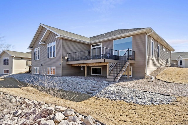 rear view of house featuring a wooden deck and stairs