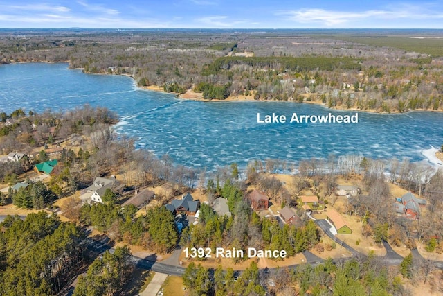 birds eye view of property with a view of trees and a water view