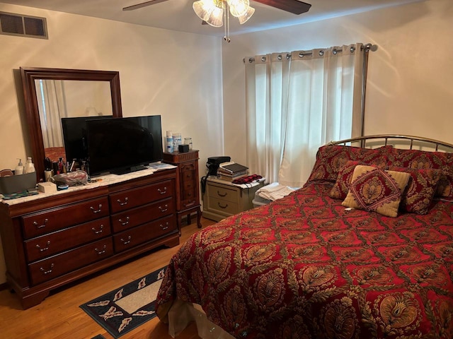 bedroom featuring a ceiling fan, visible vents, and light wood-type flooring