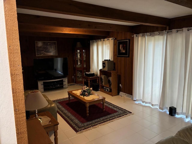 living area with beamed ceiling and wood walls