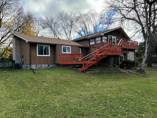 rear view of property featuring a deck, stairway, and a lawn