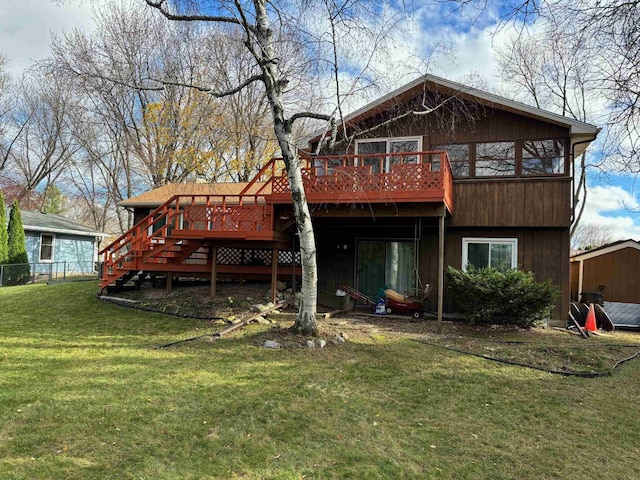 back of property with a yard, a deck, and stairway