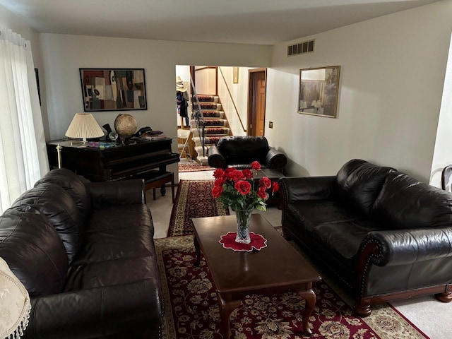 living area featuring stairs, carpet flooring, and visible vents