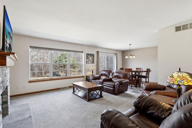 carpeted living room with a notable chandelier, visible vents, a brick fireplace, and baseboards