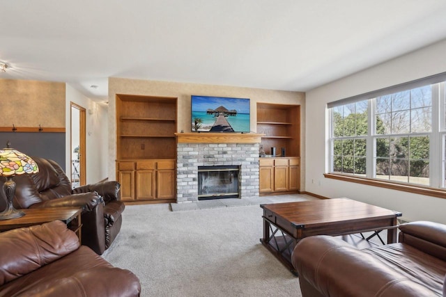 living area with built in features, light colored carpet, and a brick fireplace