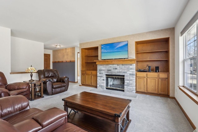 living area featuring built in shelves, a fireplace, baseboards, and light carpet