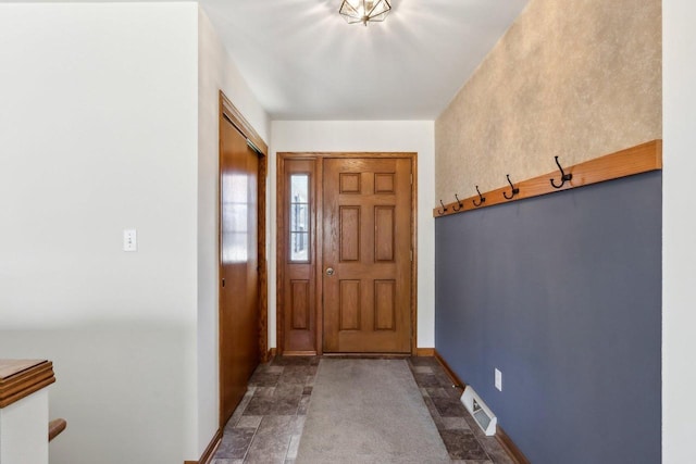 foyer featuring baseboards and visible vents