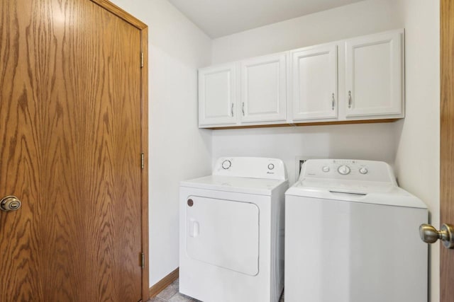 clothes washing area with washer and dryer, cabinet space, and baseboards