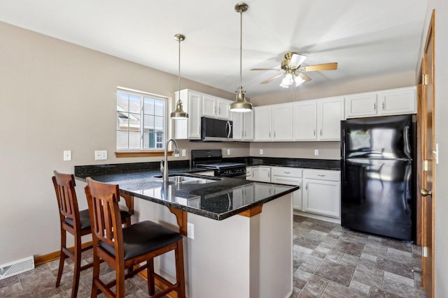 kitchen with visible vents, black appliances, a sink, a peninsula, and white cabinets