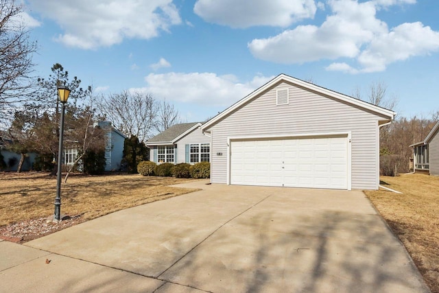 view of front of home featuring an attached garage, concrete driveway, and a front lawn