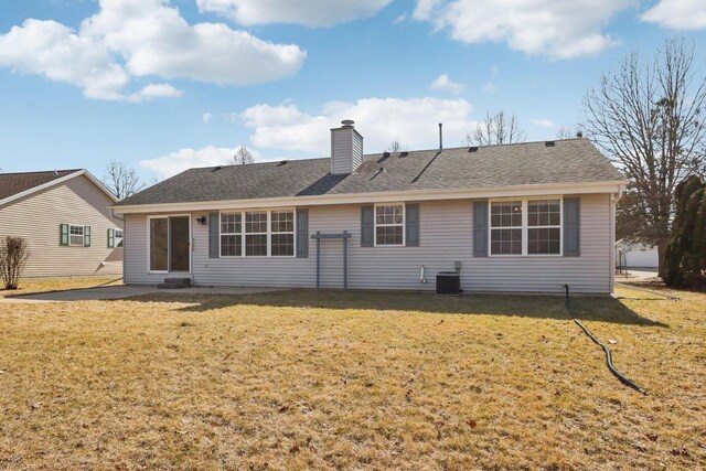 back of house featuring a lawn, central AC unit, a chimney, and a shingled roof