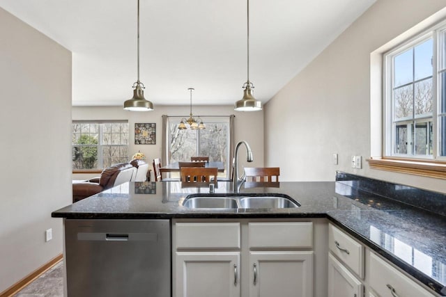 kitchen with dishwasher, dark stone countertops, white cabinets, and a sink