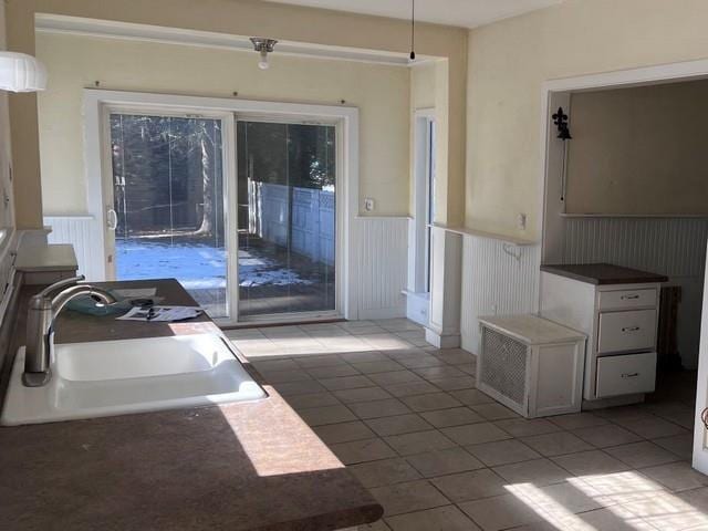 interior space featuring a sink, wainscoting, and light tile patterned floors