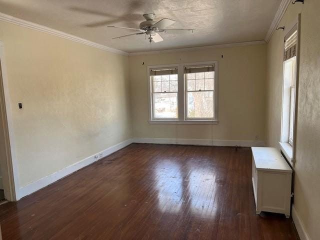 spare room with baseboards, a ceiling fan, dark wood finished floors, and crown molding