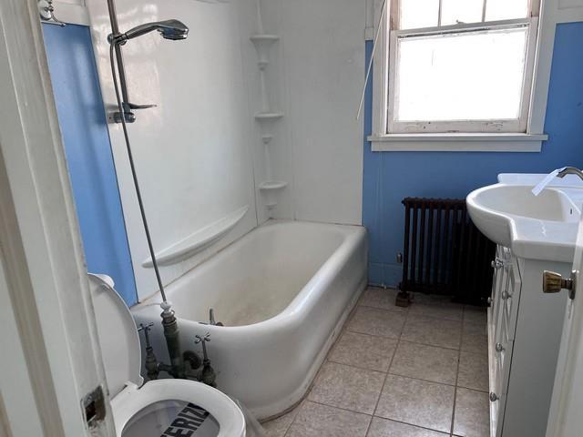 bathroom with vanity, tile patterned floors, and radiator heating unit