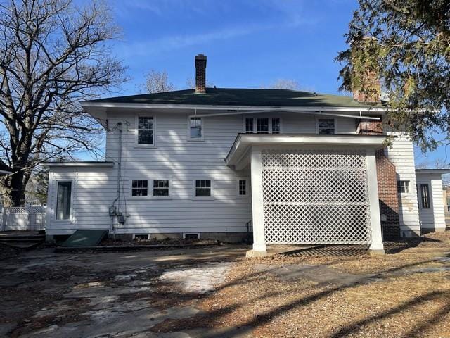 back of house featuring a chimney