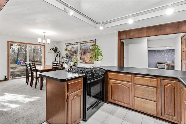 kitchen with dark countertops, brown cabinets, and black range with gas stovetop