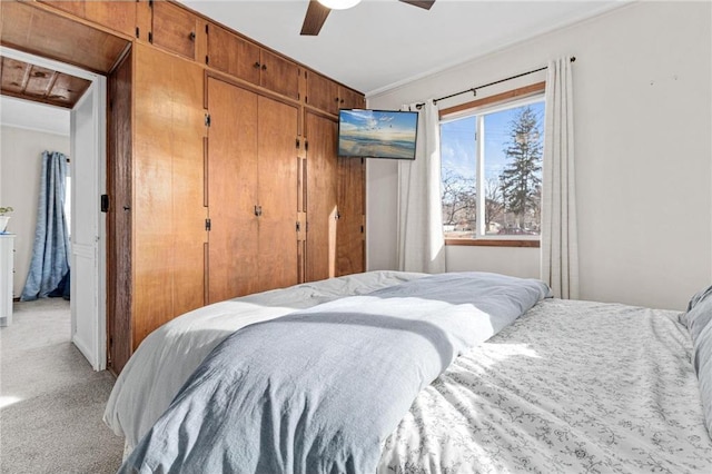 bedroom featuring light carpet, a ceiling fan, and a closet