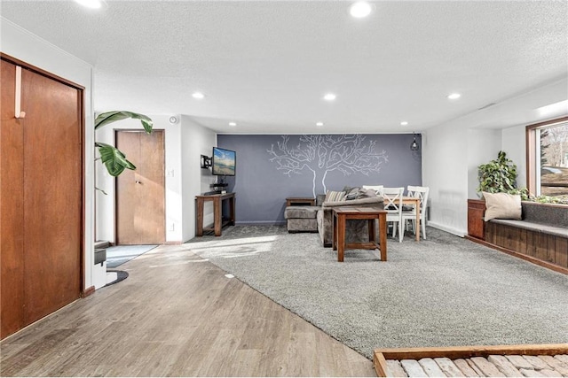 interior space with recessed lighting, baseboards, a textured ceiling, and wood finished floors