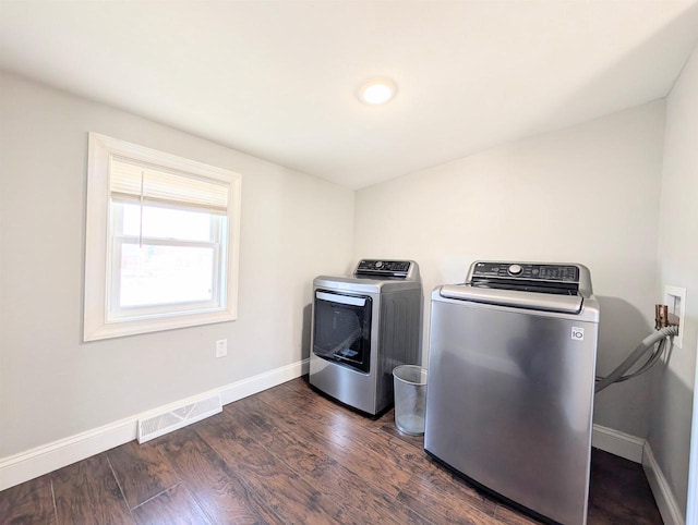 washroom featuring baseboards, visible vents, laundry area, dark wood-style flooring, and washer and dryer