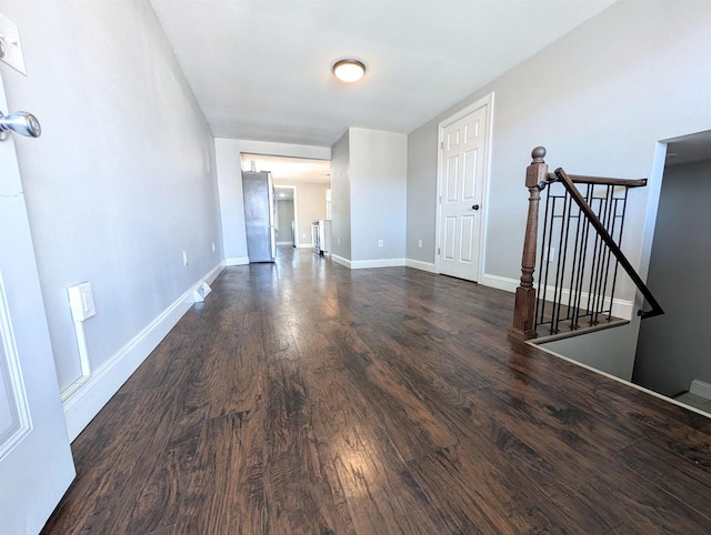 empty room with baseboards and dark wood-style flooring