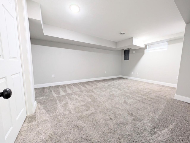 below grade area with electric panel, carpet flooring, and baseboards