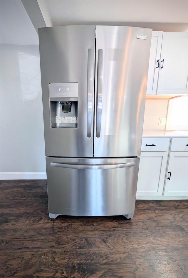 interior details featuring light countertops, white cabinets, dark wood-style floors, and stainless steel fridge