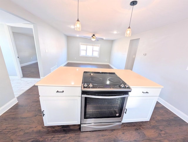 kitchen with hanging light fixtures, open floor plan, white cabinetry, and electric stove