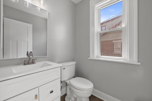 bathroom featuring vanity, toilet, and baseboards