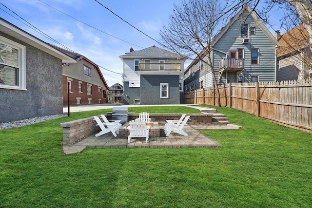 back of property with a patio, a balcony, a yard, and fence