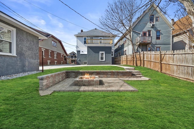 back of house featuring a yard, a patio, a fire pit, and fence