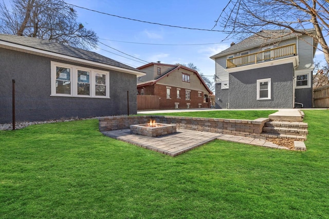 view of yard featuring a patio, a fire pit, and fence