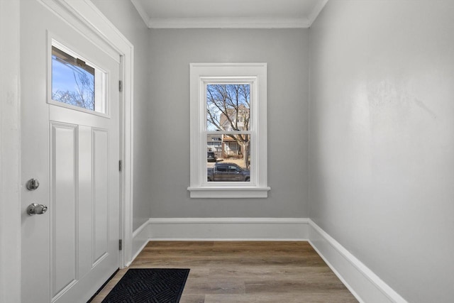 foyer with baseboards, wood finished floors, and ornamental molding