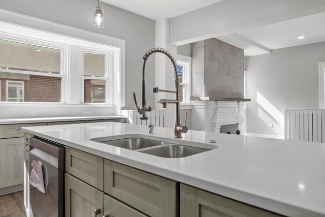 kitchen featuring pendant lighting, light wood-type flooring, light countertops, and a sink