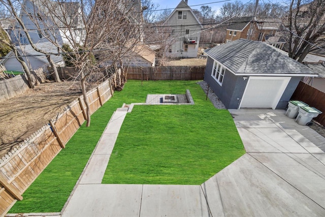 view of yard with a fenced backyard, driveway, and a garage