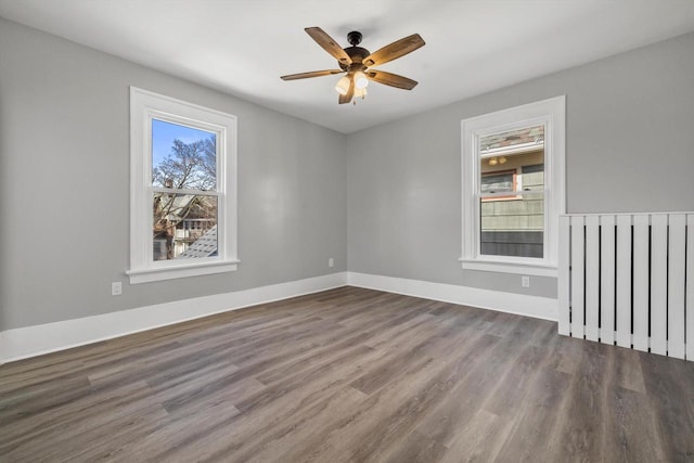 unfurnished room featuring ceiling fan, baseboards, and wood finished floors