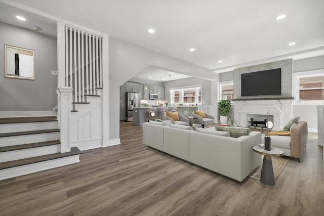 living room featuring stairs, recessed lighting, and wood finished floors