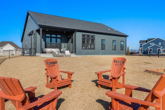 back of property featuring a shingled roof, a fenced backyard, and a patio area