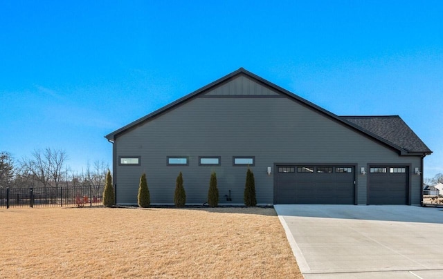 view of home's exterior with a yard, an attached garage, driveway, and fence