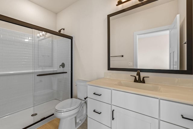 bathroom featuring vanity, toilet, and a stall shower