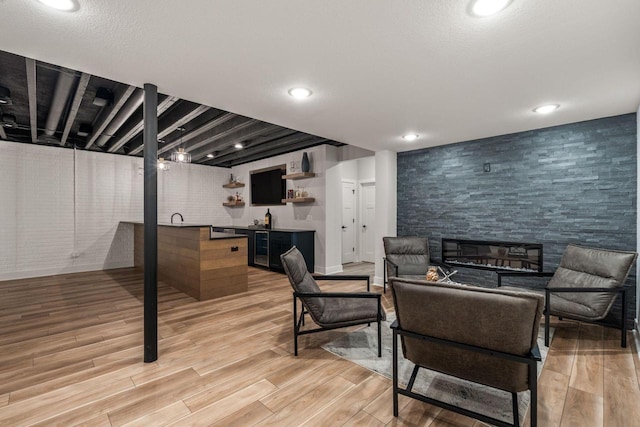 living room with recessed lighting, wet bar, beverage cooler, and light wood-style flooring