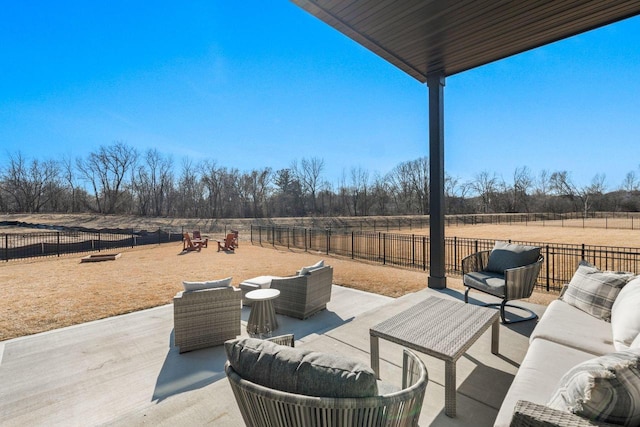 view of patio featuring outdoor lounge area, fence, and a rural view