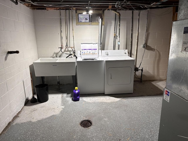 laundry area with washer and dryer, laundry area, heating unit, and a sink