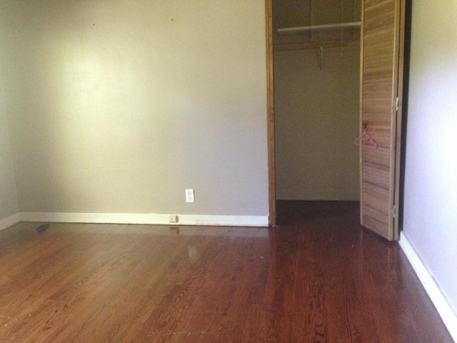 unfurnished bedroom with a closet, baseboards, and wood finished floors