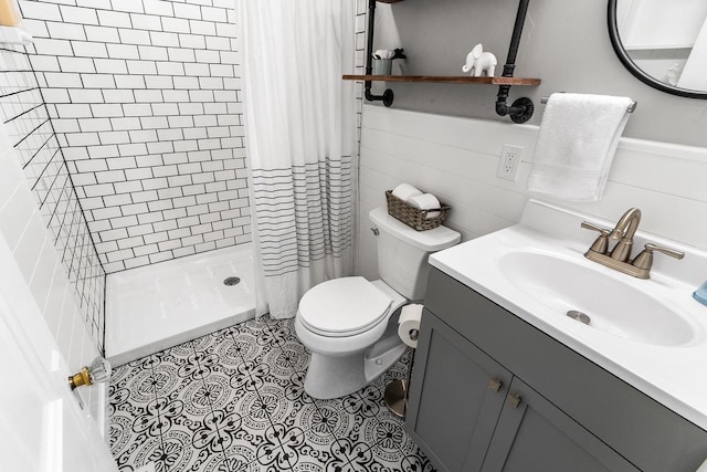 full bath featuring tile patterned floors, vanity, toilet, and a shower stall