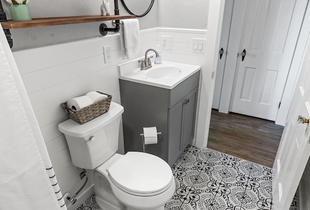 bathroom with vanity, toilet, and wainscoting