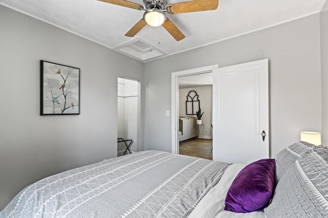 bedroom with attic access, ceiling fan, and wood finished floors