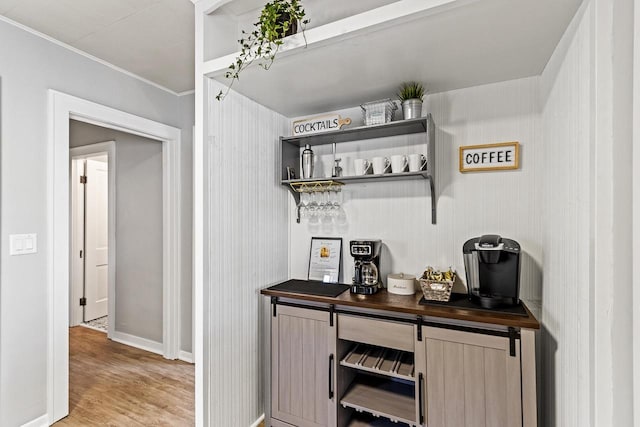 bar with crown molding, light wood-style floors, and baseboards