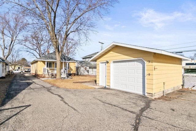 exterior space featuring an outbuilding, fence, a garage, and driveway