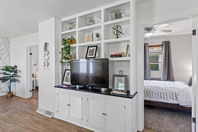 interior space featuring wood finished floors, a ceiling fan, and visible vents